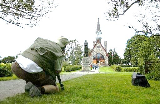 A visitor photographs the iconic statue of Evangeline, heroine of Longfellow's epic poem about the Acadian expulsion, at the deportation memorial in Grand-Pré, Nova Scotia. (Times-Picayune photo by Brett Duke)